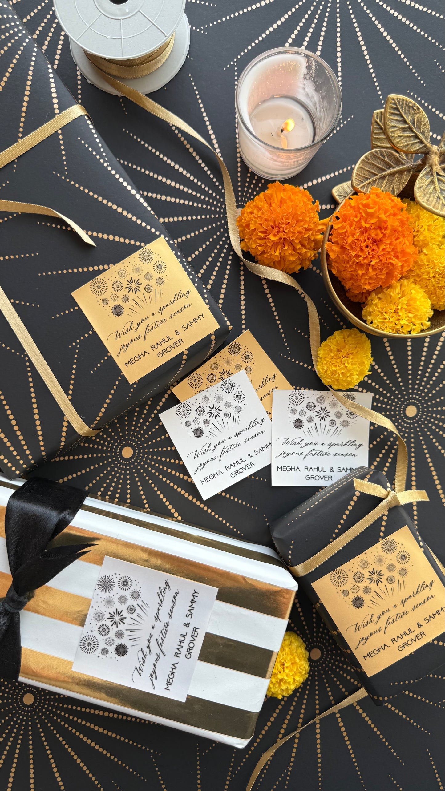 Decorative gift packaging with gold ribbons, candles, and floral elements on a black and gold patterned background.
