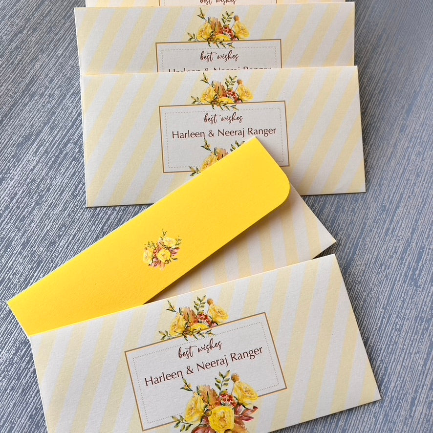 Personalized yellow and cream striped envelopes with yellow floral illustrations, shown with matching envelopes on a gray textured surface.