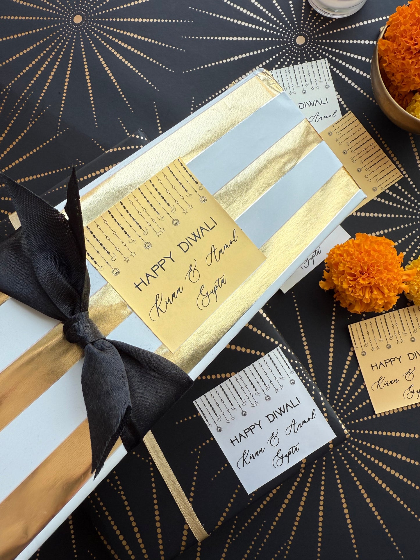 Gift box with gold card and black ribbon on a decorative background