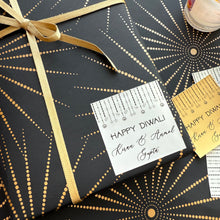 Gift box with 'Happy Diwali' card on black and gold patterned paper