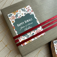 Gift box with a decorative label reading 'Happy Diwali' on a wooden surface.