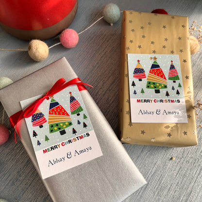 Two wrapped gifts with personalized Christmas-themed tags that read 'Merry Christmas' and 'Abhi & Aya'.