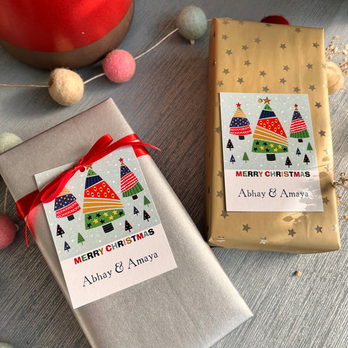 Two wrapped gifts with personalized Christmas-themed tags that read 'Merry Christmas' and 'Abhi & Aya'.