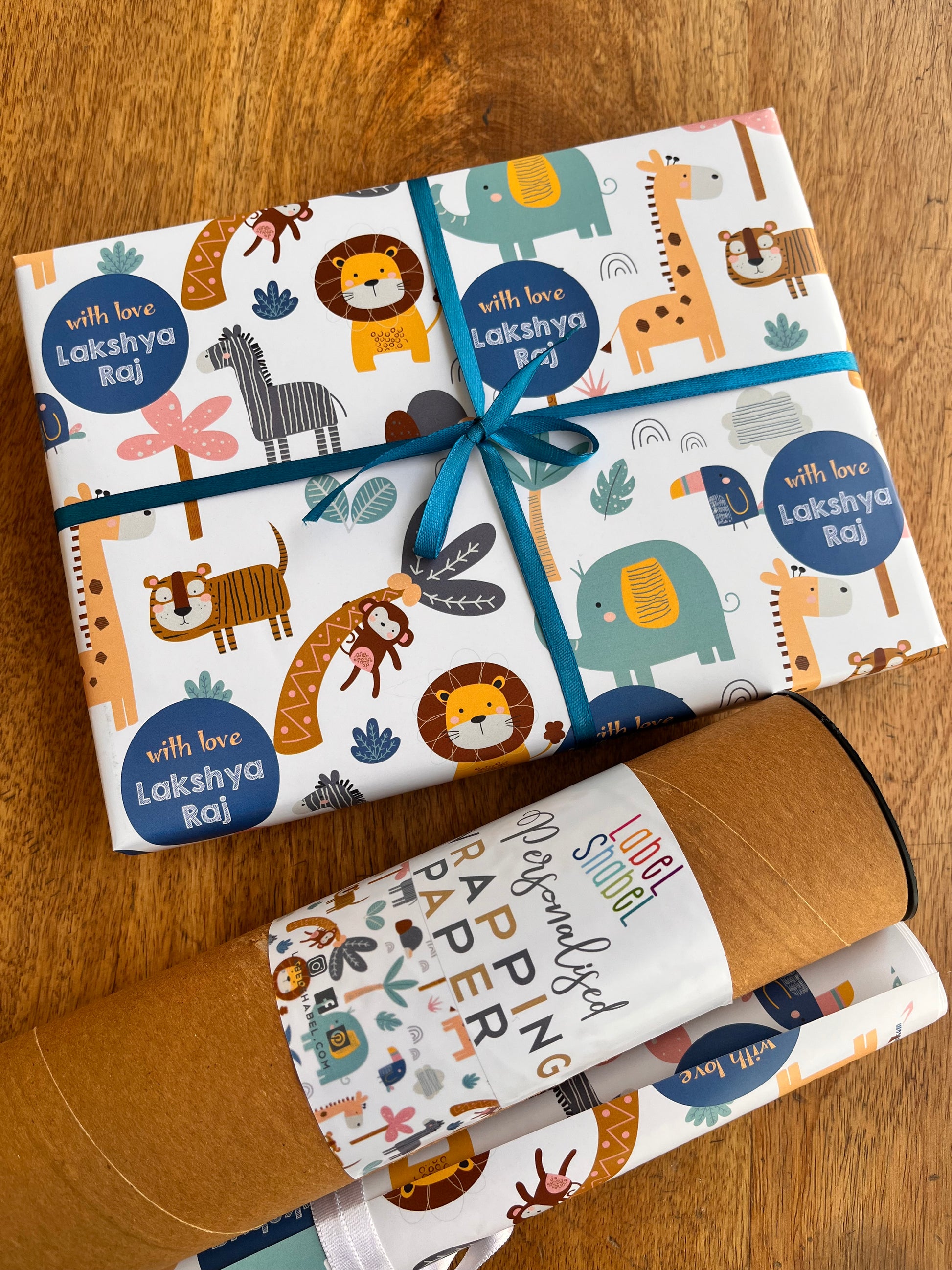 a gift wrapped in personalised wrapping paper with cute jungle animals design of a lion, monkey, elephant, giraffe 