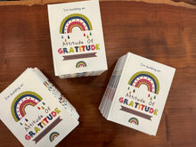 Stack of 'Attitude of Gratitude' Journals on a wooden surface