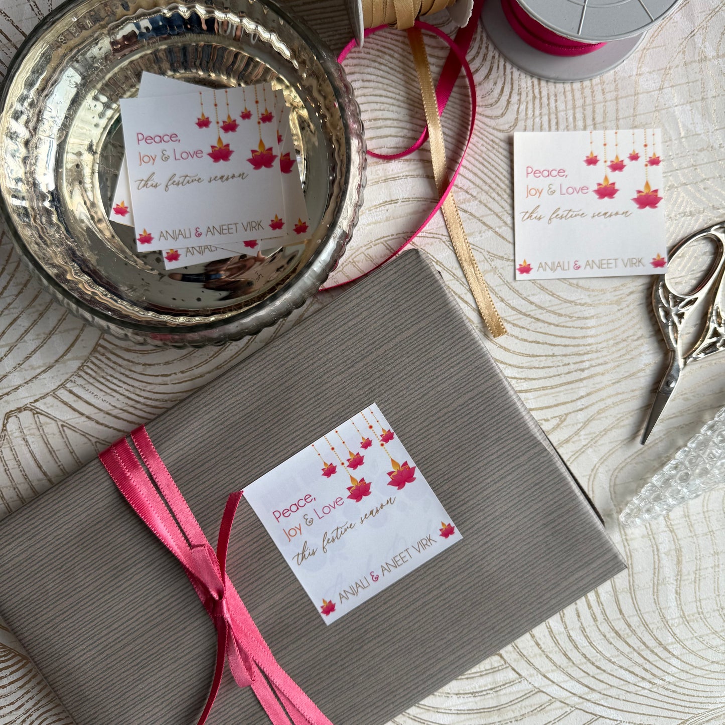 Gift box with pink ribbon and decorative label on a textured surface