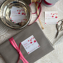 Gift box with pink ribbon and decorative label on a textured surface