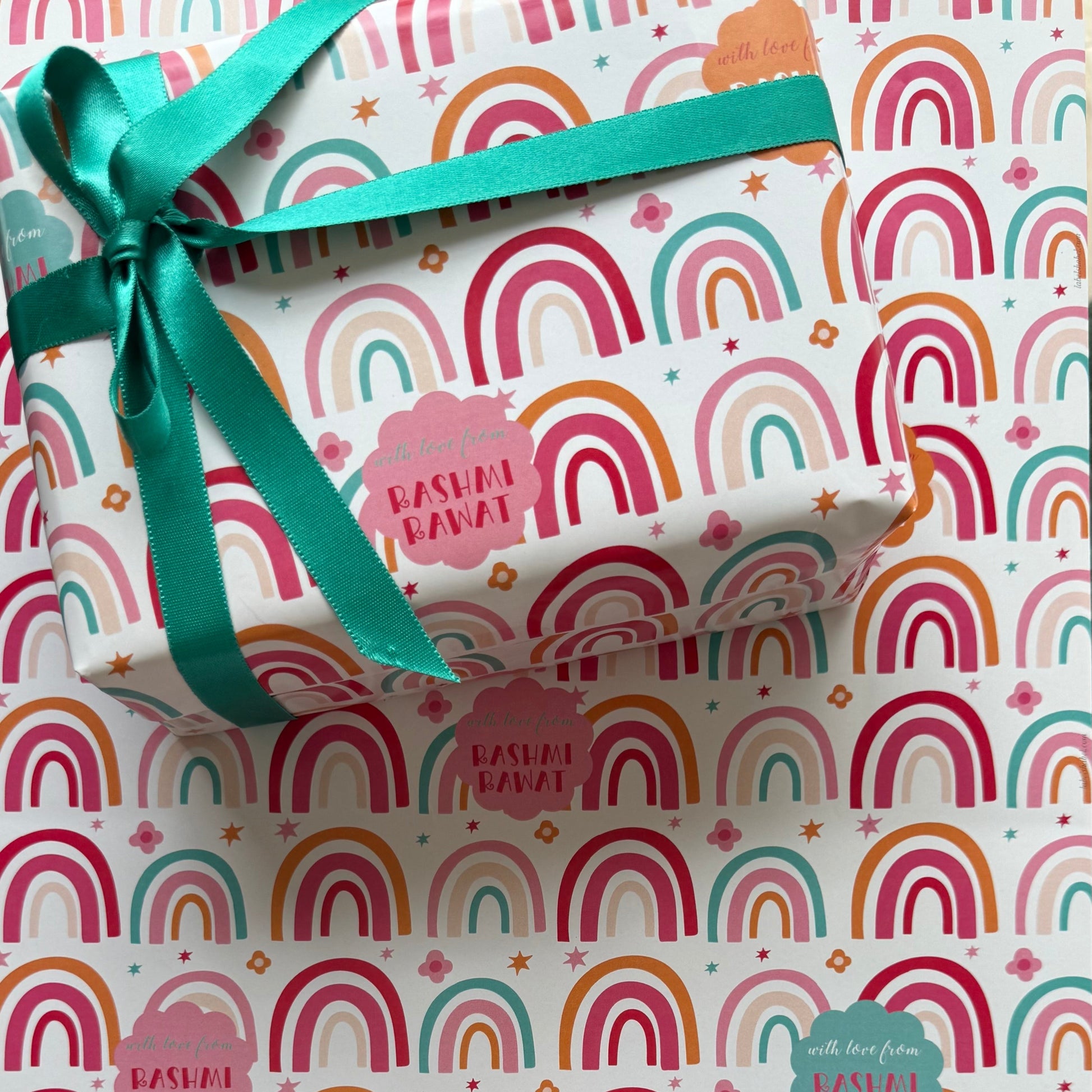 Colour ful pink hues rainbows on what background with cloud bubbles featuring personalised name and greeting