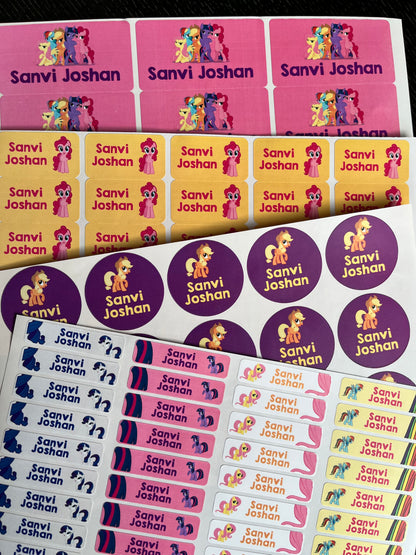 Custom printed sticker sheets featuring cartoon pony characters and the names 'Sanvi Joshan' in multiple colorways, including pink, yellow, purple, and blue.