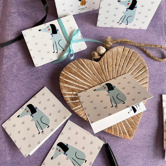 folded gift tag with cute dog in blue on background of grey hearts and a cute dog inside with name