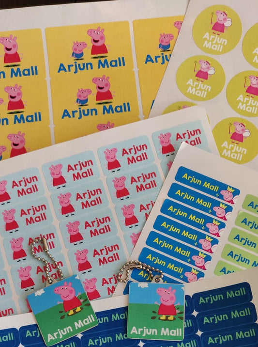 Multiple sheets of colorful custom name stickers featuring the Peppa Pig character and the text 'Arjun Mall', arranged on a white surface.