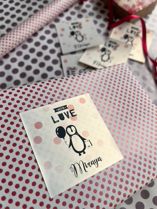 A close-up of wrapped gift boxes and paper tags featuring a pink and white polka dot pattern.