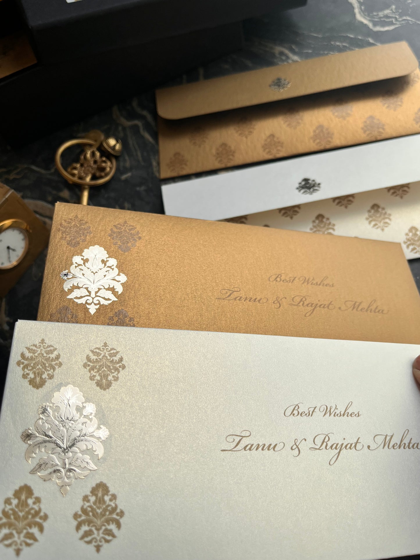 Decorative envelopes with floral designs on a marble surface.