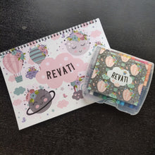 a drawing set of art book and box of personalised crayons with a pastel shade airballoons and flowers, clouds rainbow
