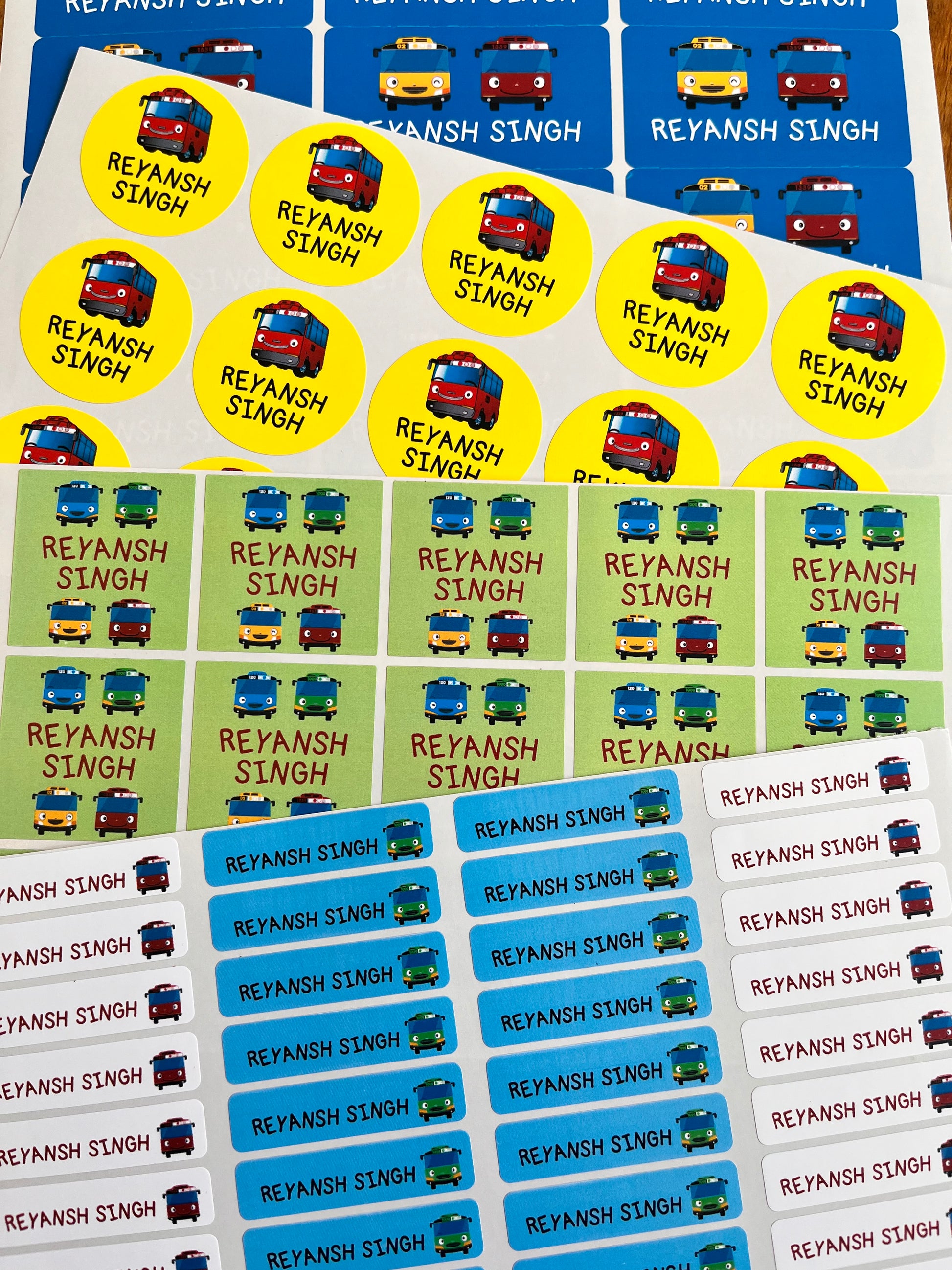 waterproof name labels with bright blue green yellow colours featuring tayo bus cartoons, personalised with a child's name