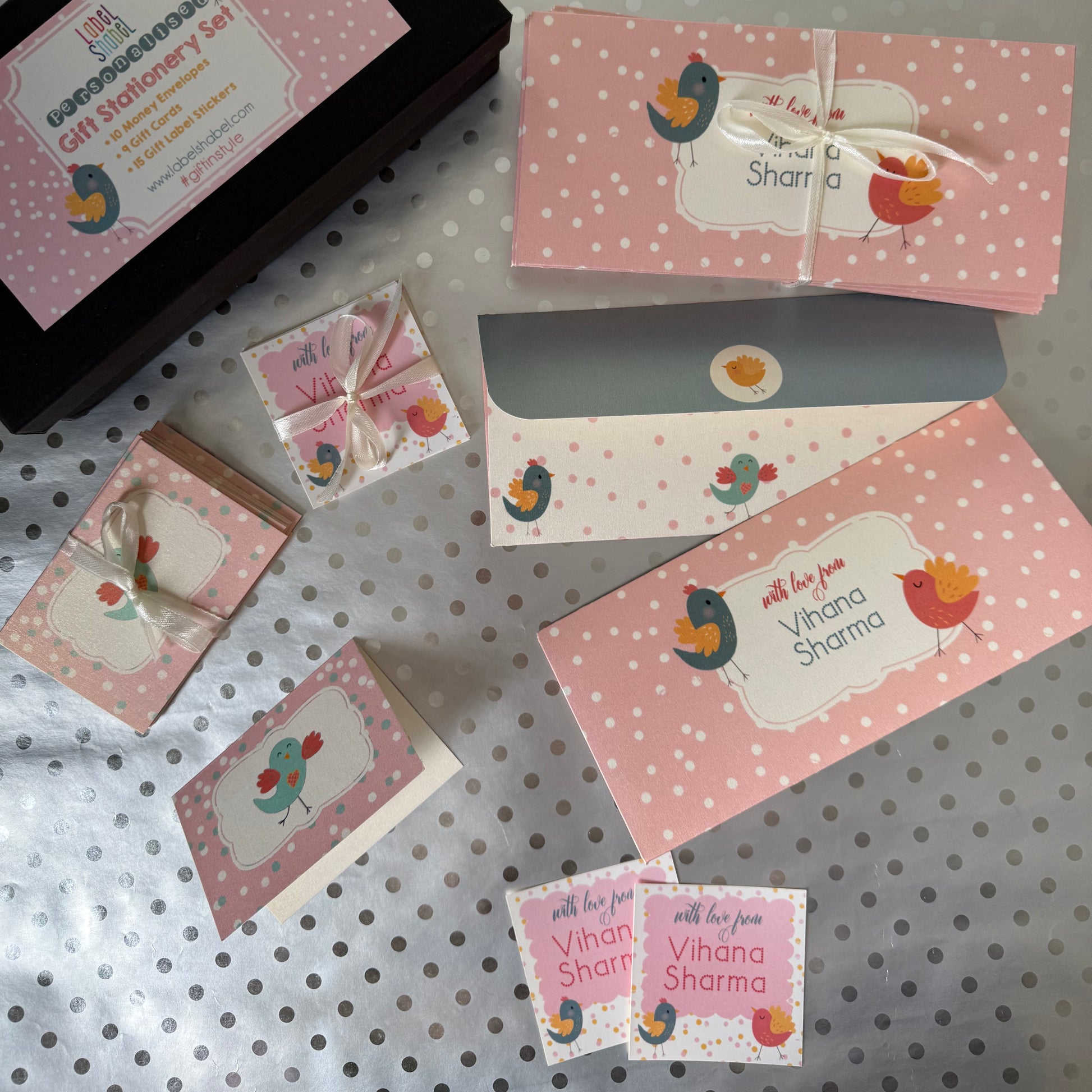 Set of pink stationery set with envelopes, gift labels and gift tags with decorative elements on a polka dot surface