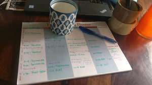 Label Shabel weekly  family planner on desktop with coffee mug and schedule written